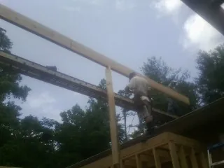 Carpenter setting a ridge beam over a new addition frame — Ice Dam Removal by Roofing Brothers in Church Road