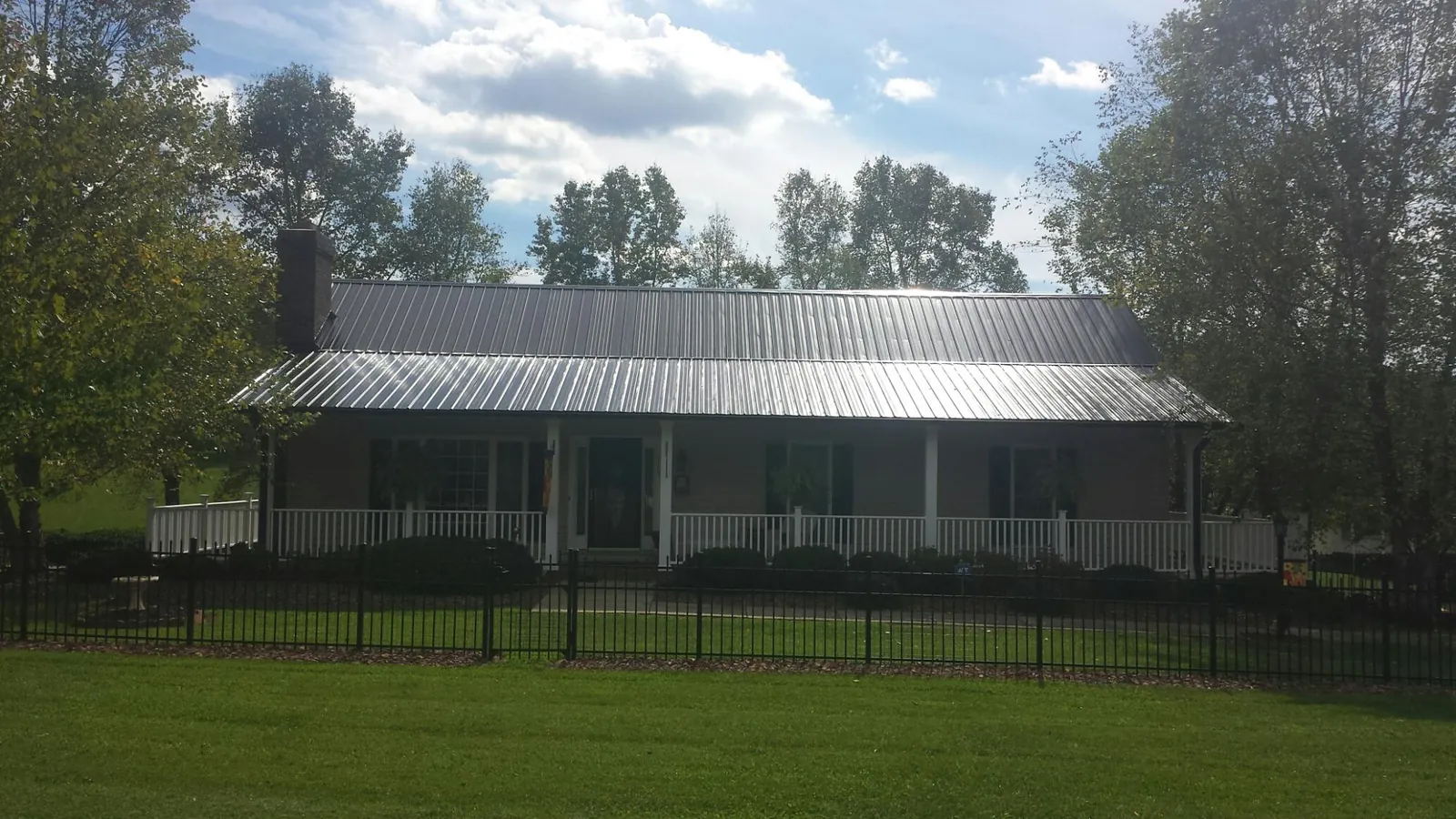Gray metal roof on a brick ranch with a full width front porch — Gutter Guard Installation work by our crew in Church Road